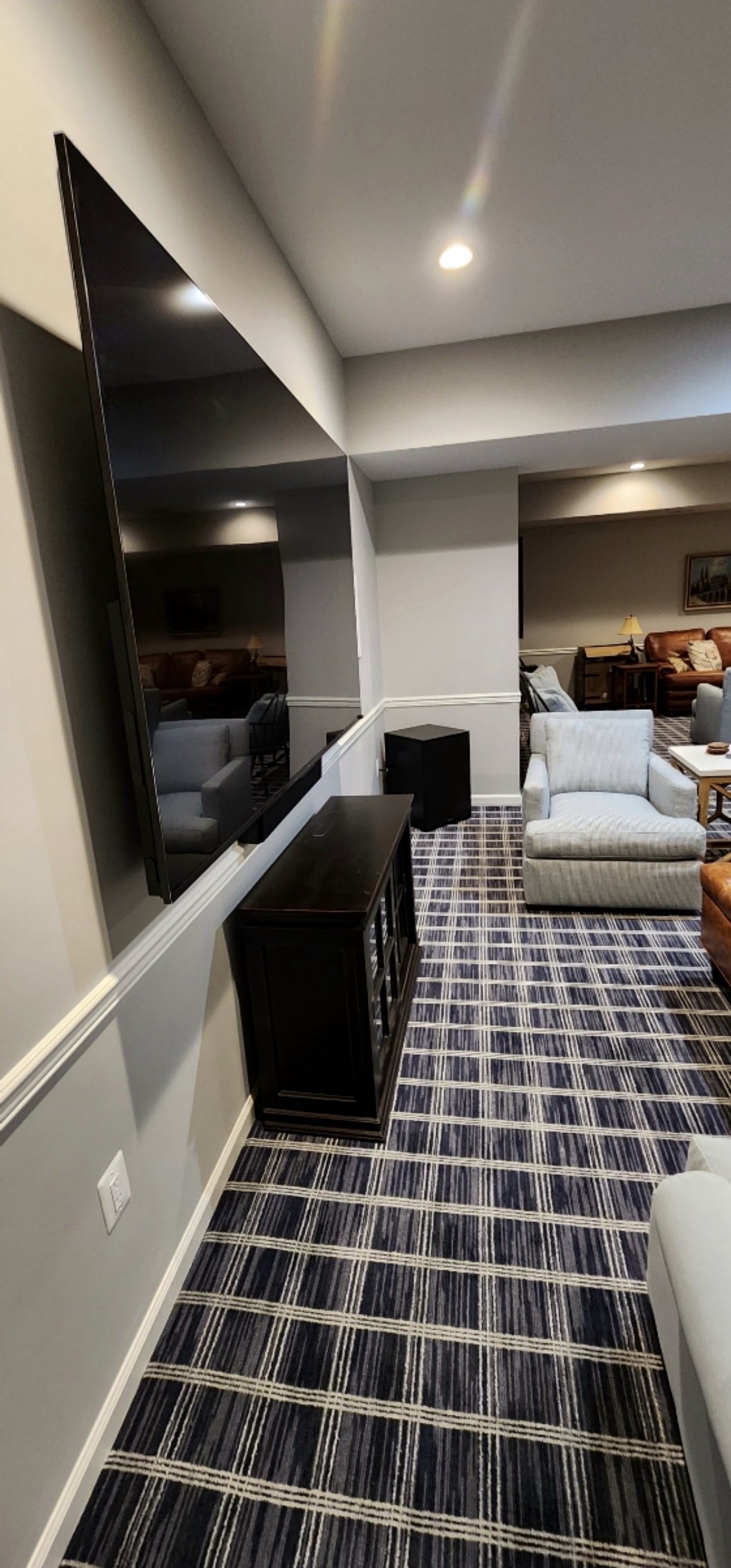 Basement media room with mounted TV and subwoofer