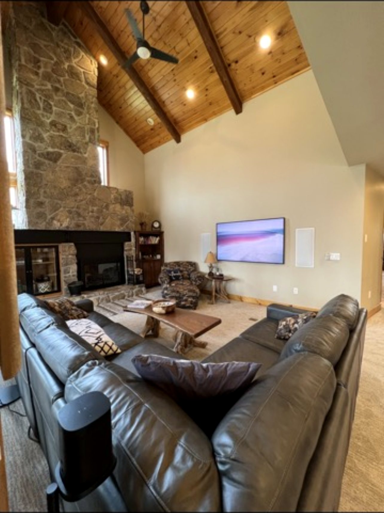 Vaulted great room with stone fireplace and TV