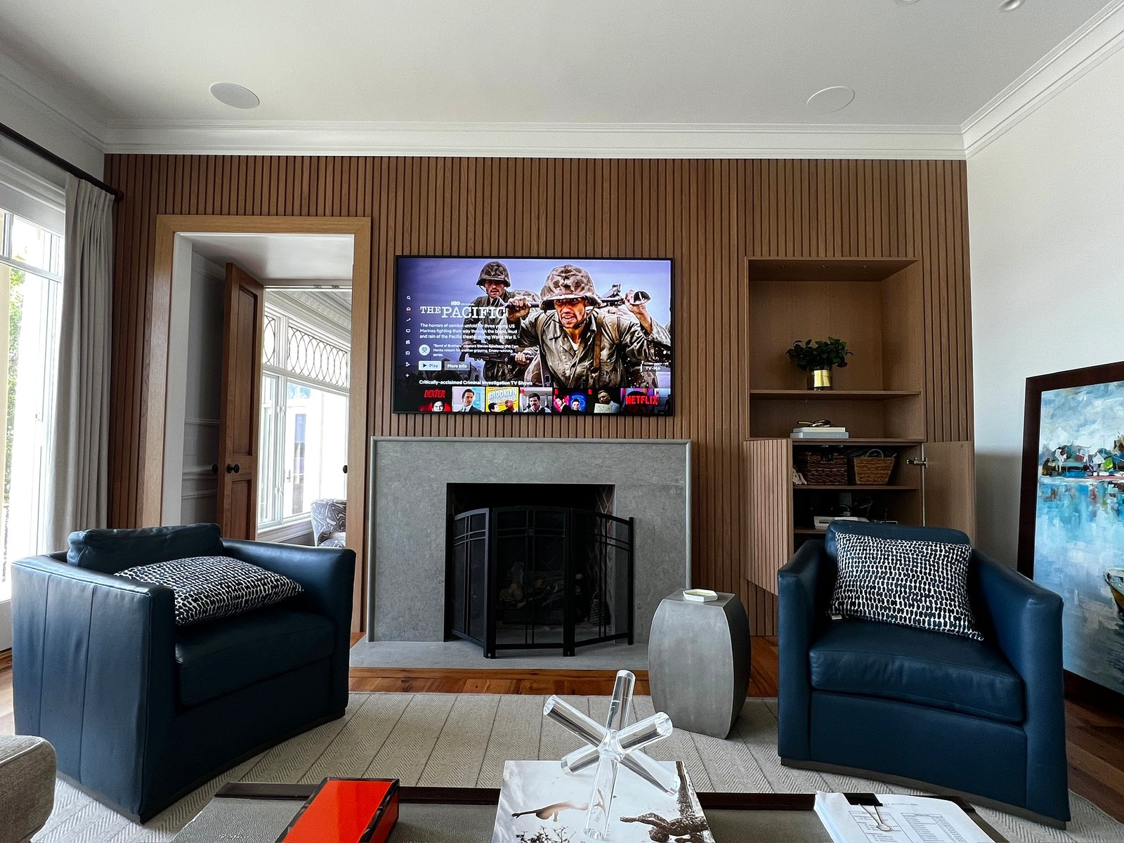 TV over fireplace on wood-slat wall